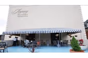 Front exterior of Regency Healthcare & Rehab Center with striped awning and outdoor seating.