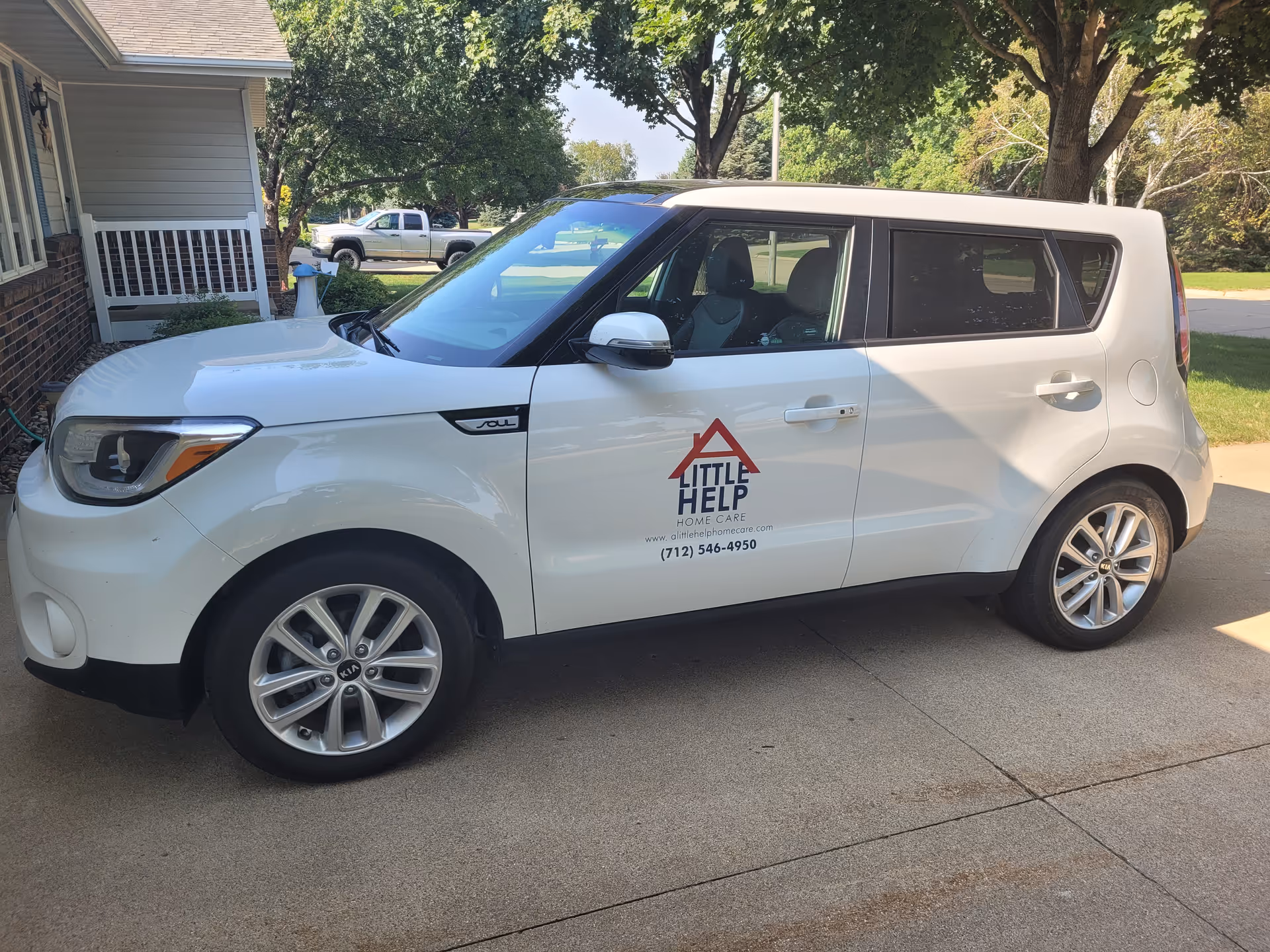White Little Help Home Care vehicle parked beside a house.