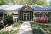 Front view of the Althea Woodland Nursing Home entrance with brick facade and greenery.