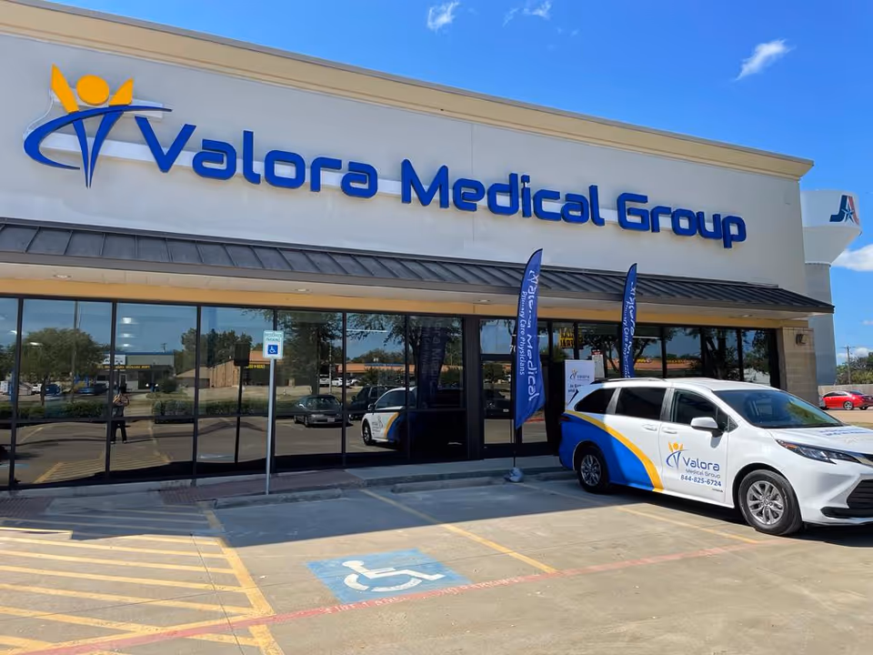 Valora Medical Group Arlington storefront with large glass windows and a parked vehicle.