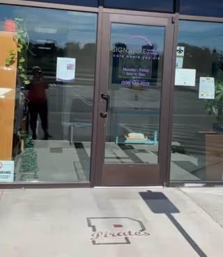 Glass front entrance of Payette Signature HCH with doors and reflections.
