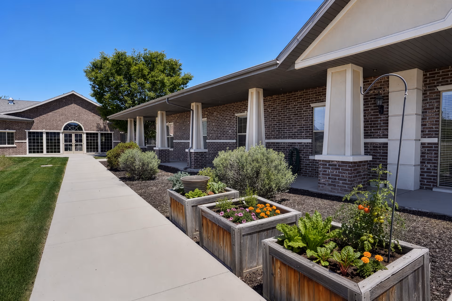 Exterior view of Rocky Mountain Care Riverton with brick building, walkway, and planter boxes.