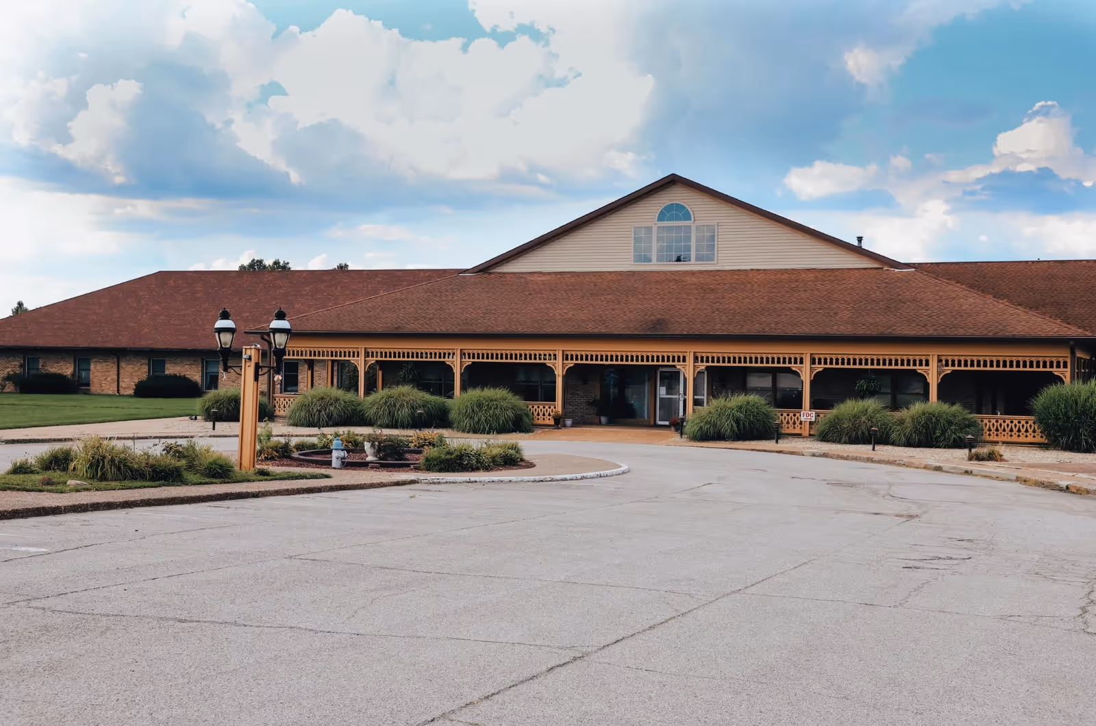 Exterior view of Loogootee Nursing Center, showing a covered porch and landscaped grounds.