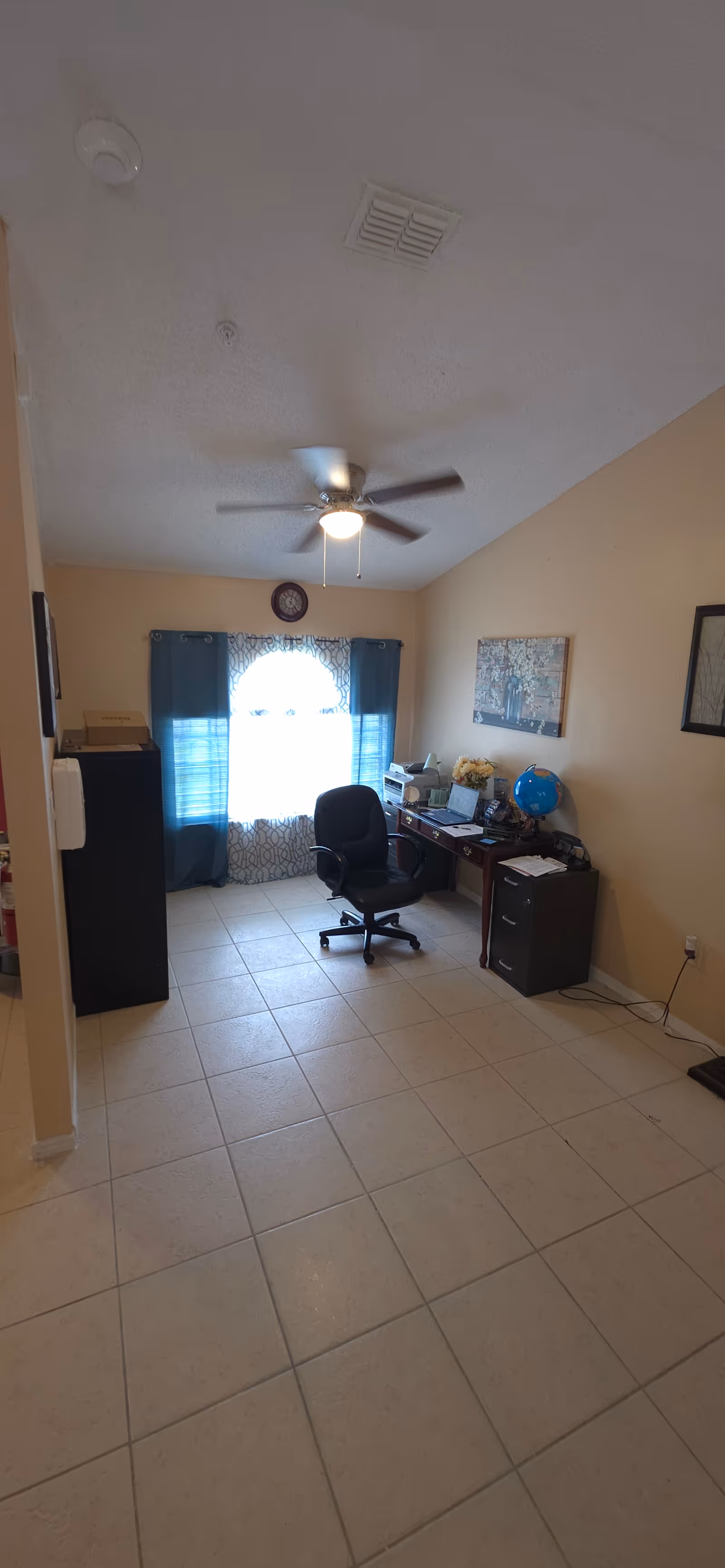 Office area inside a senior living facility with desk, chair, computer, and window.