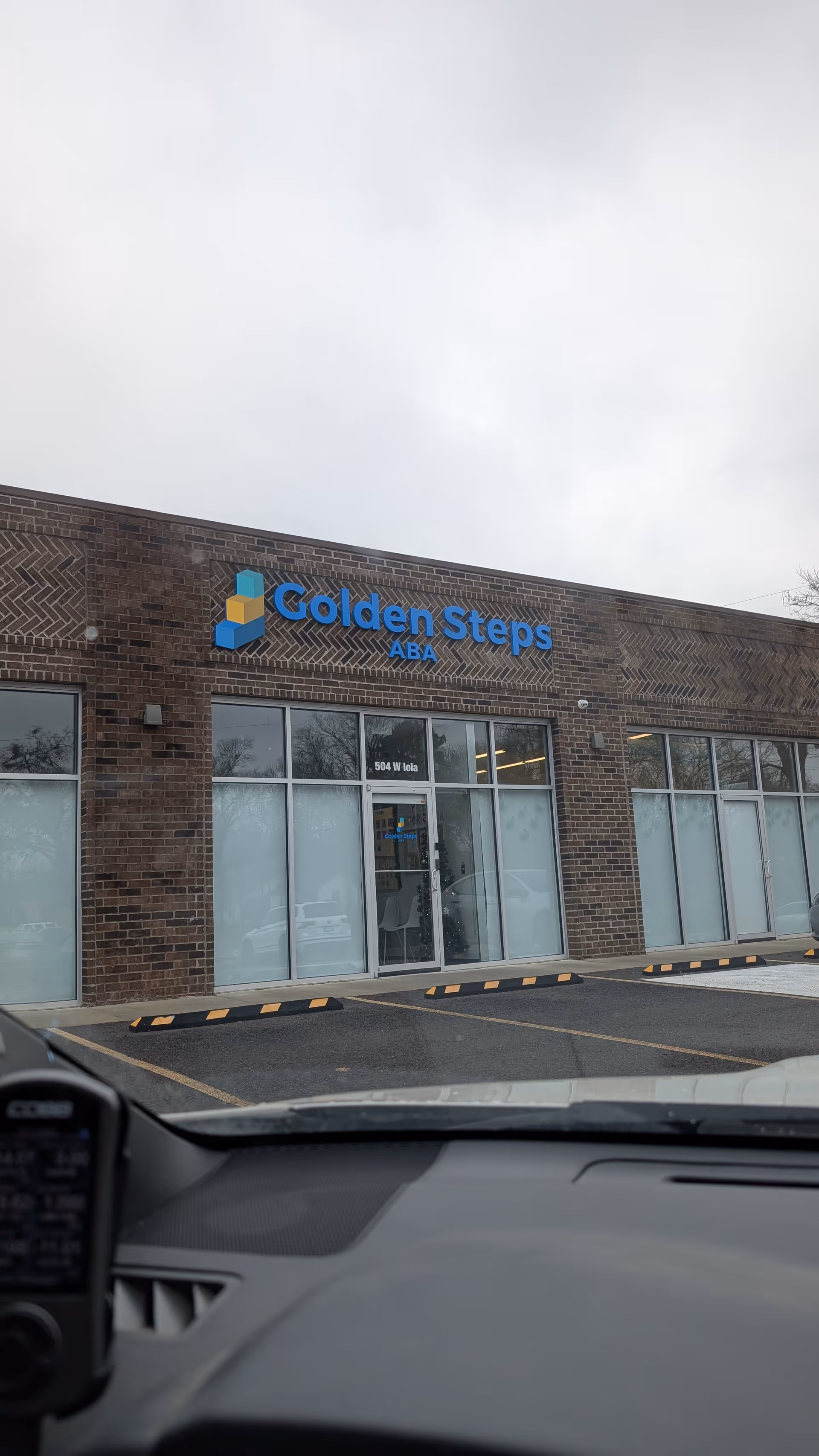 Front exterior of Golden Steps ABA building with glass entrance and sign visible