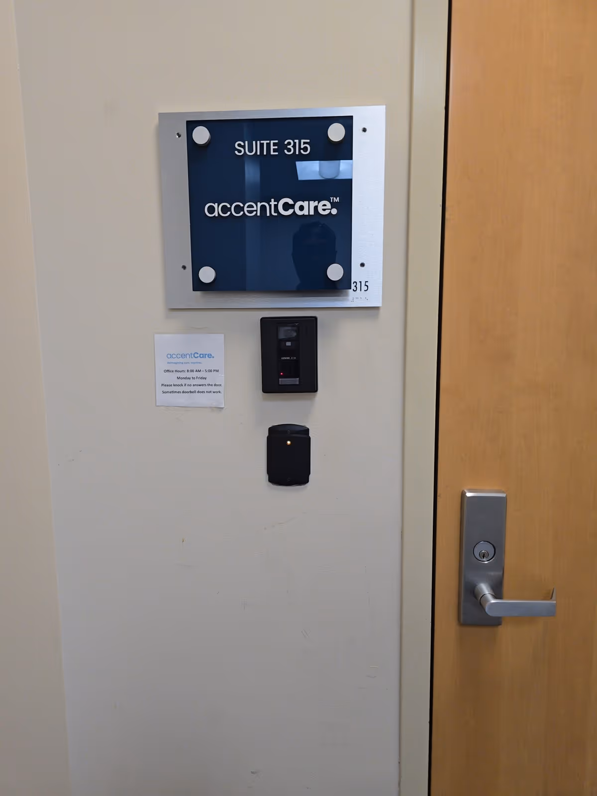 Interior wall with AccentCare Suite 315 sign and door handle.