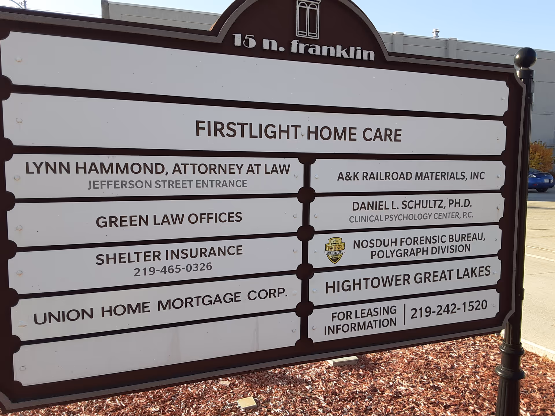 Outdoor directory sign for FirstLight Home Care with multiple business listings.