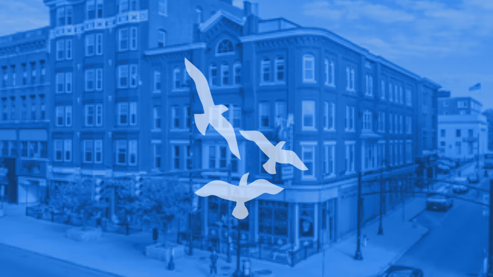 Blue-tinted exterior view of a multi-story senior residence with a bird silhouette overlay.