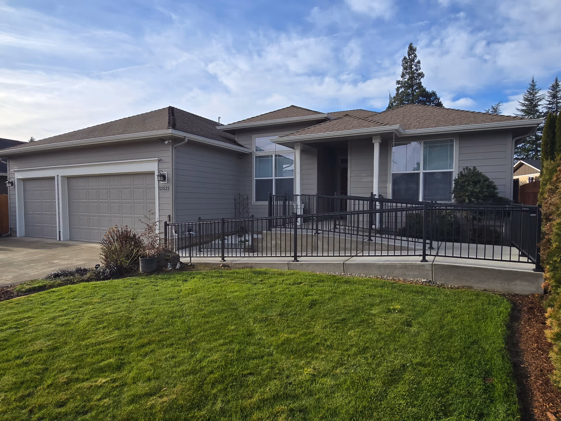 Front exterior of a single-story house with a ramp and two-car garage.