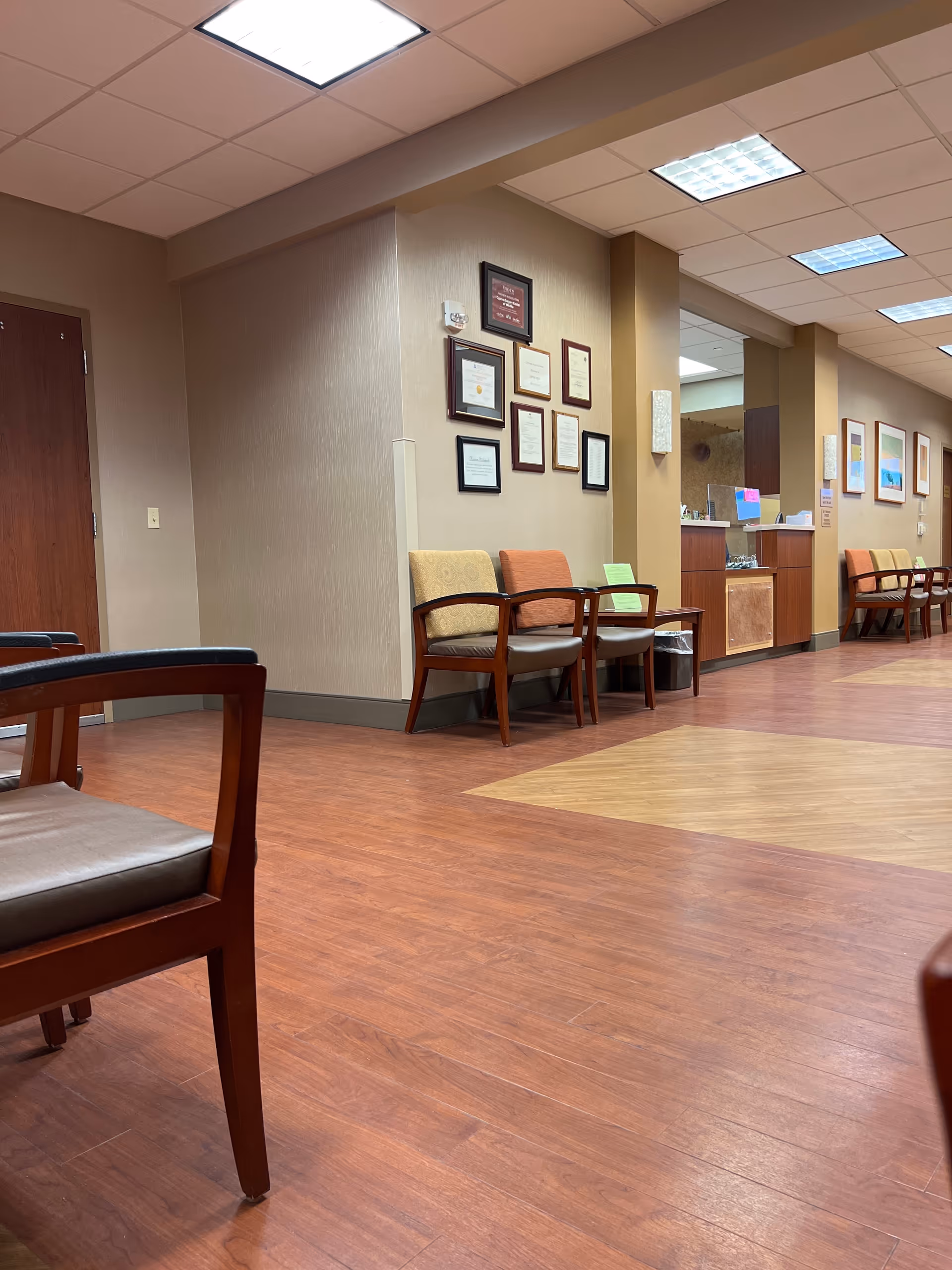 Waiting area in a Cypress Surgery Center with chairs, certificates, and a reception desk.