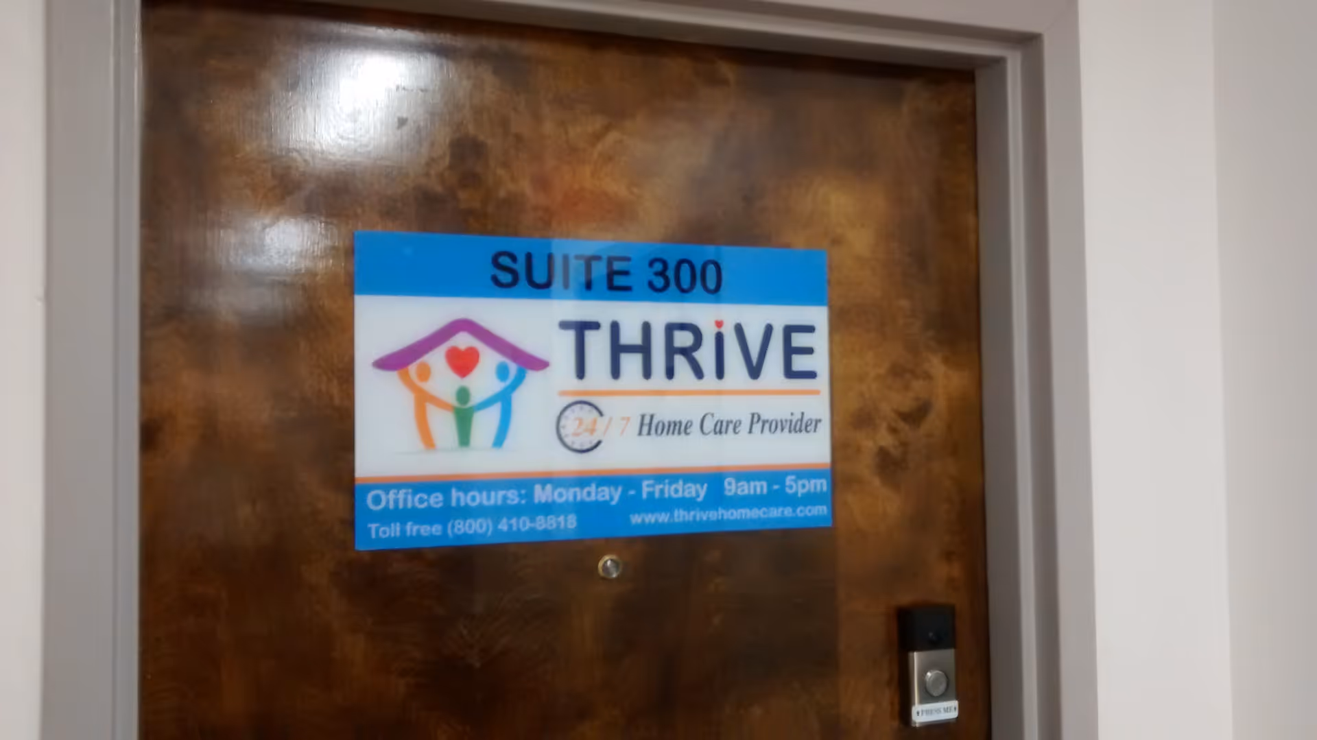 Wooden door with a blue Thrive Suite 300 Home Care Provider sign.