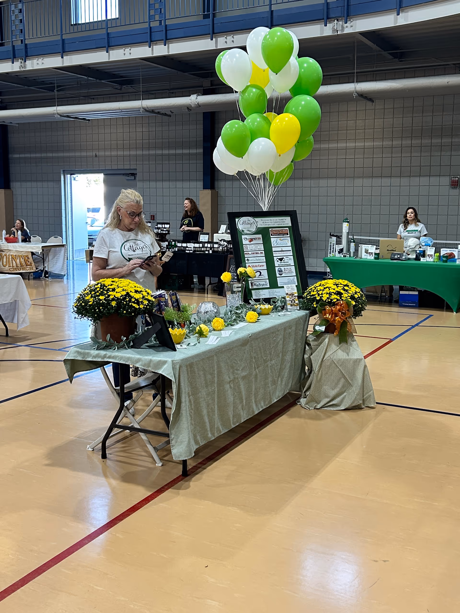 Indoor gym featuring a Cornerstone Home Health booth with balloons and decor.
