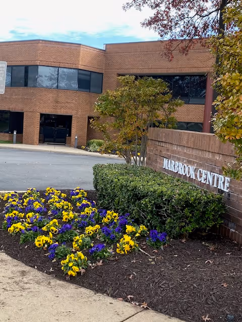 Brick senior care facility exterior with landscaped flower beds and a sign reading Harbrook Centre.