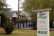 Grassy outdoor area with a sign reading Senior Villages beside a building entrance.