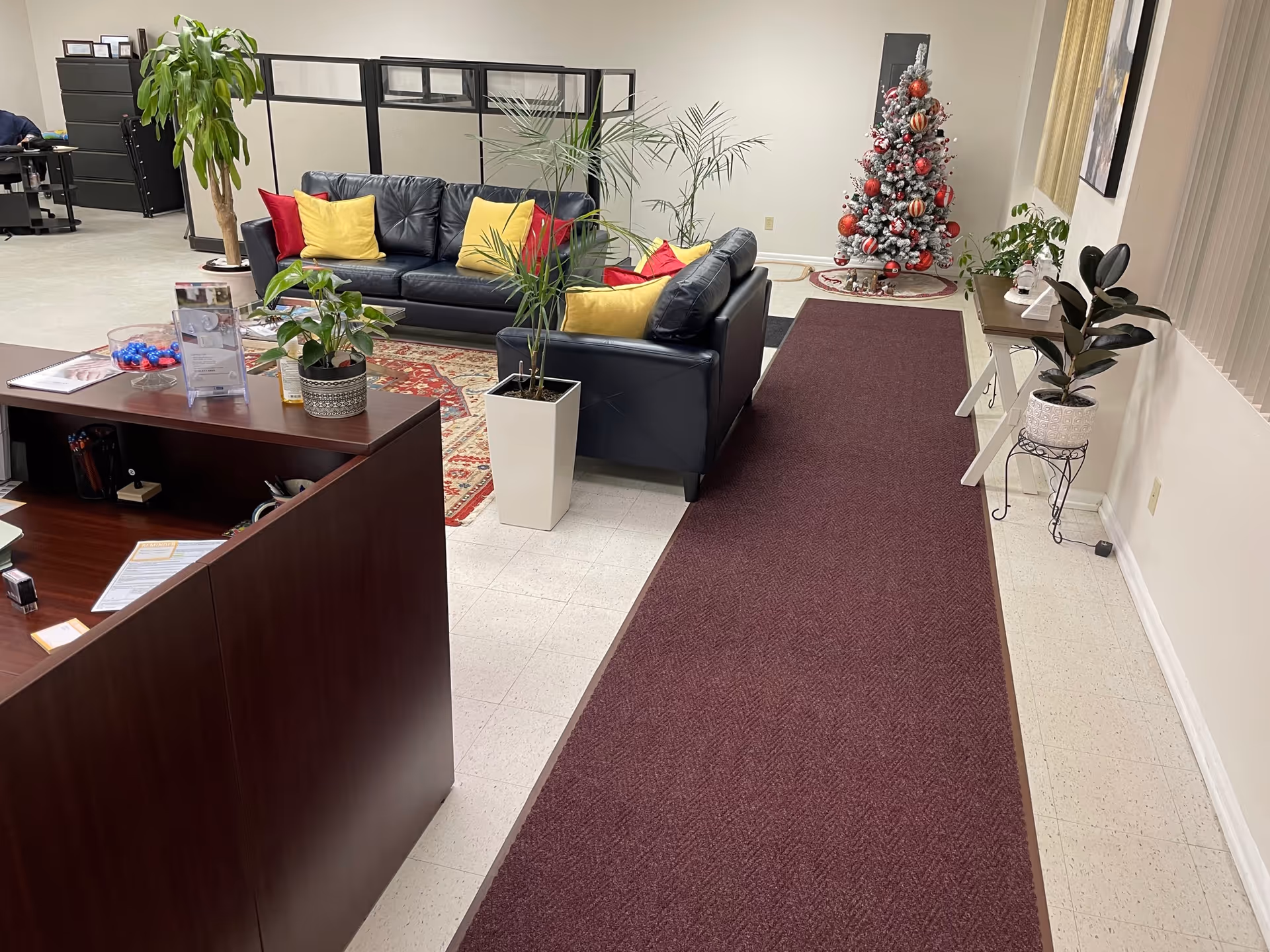 Lobby area of a senior living facility with a sofa, plants, and a Christmas tree.