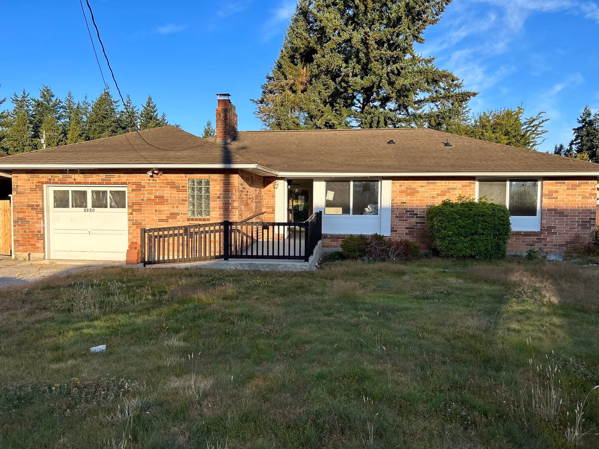 A single-story brick building with front entrance ramp and grassy yard.