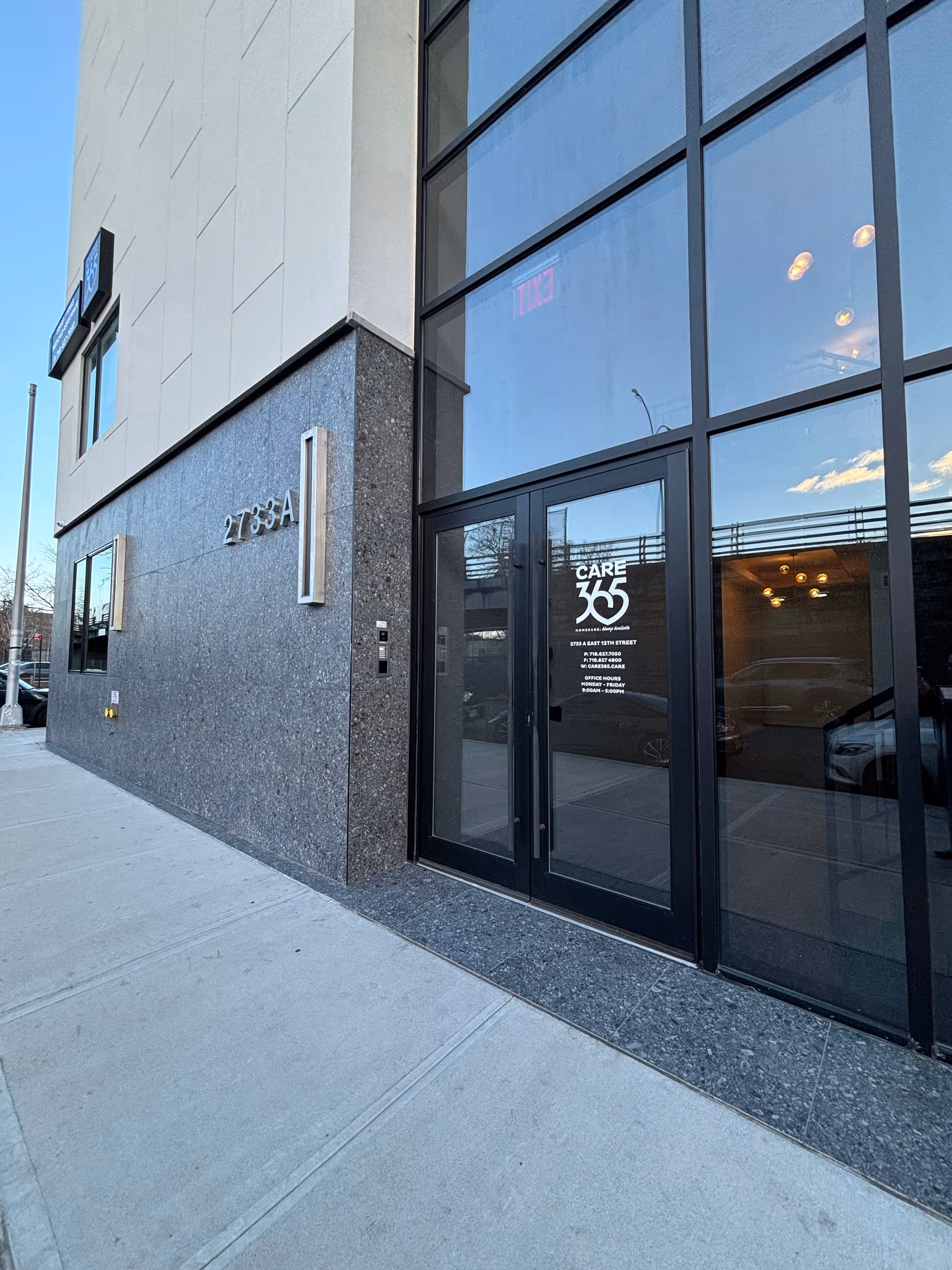 Exterior view of a modern building entrance with glass doors and Care365 sign