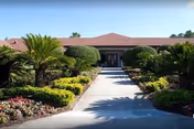Front exterior of Westchester Gardens Health & Rehabilitation, with a paved walkway and manicured landscaping.