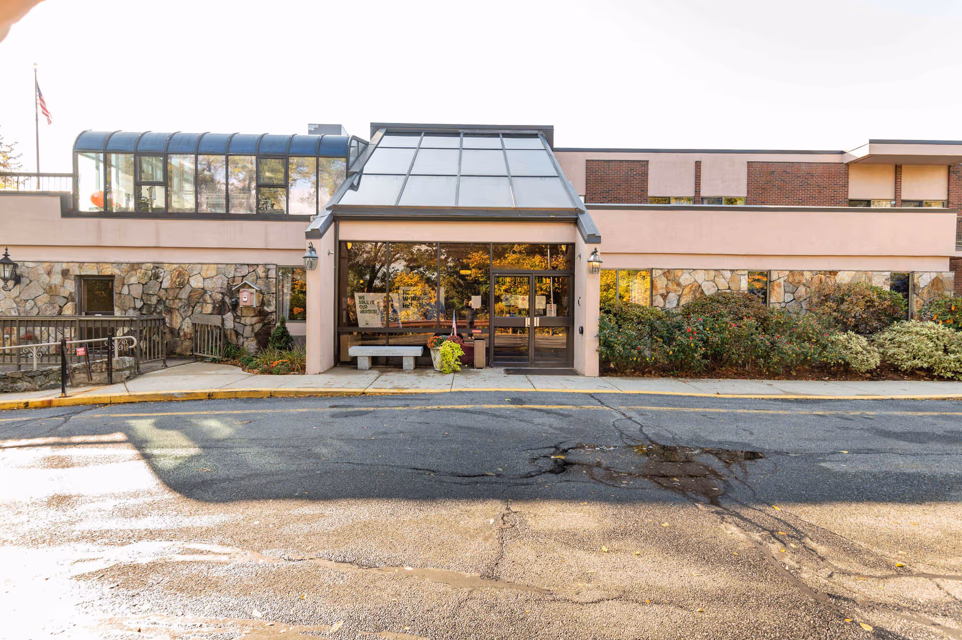 Front view of Bear Hill Nursing Center at Wakefield with glass entrance canopy and landscaping