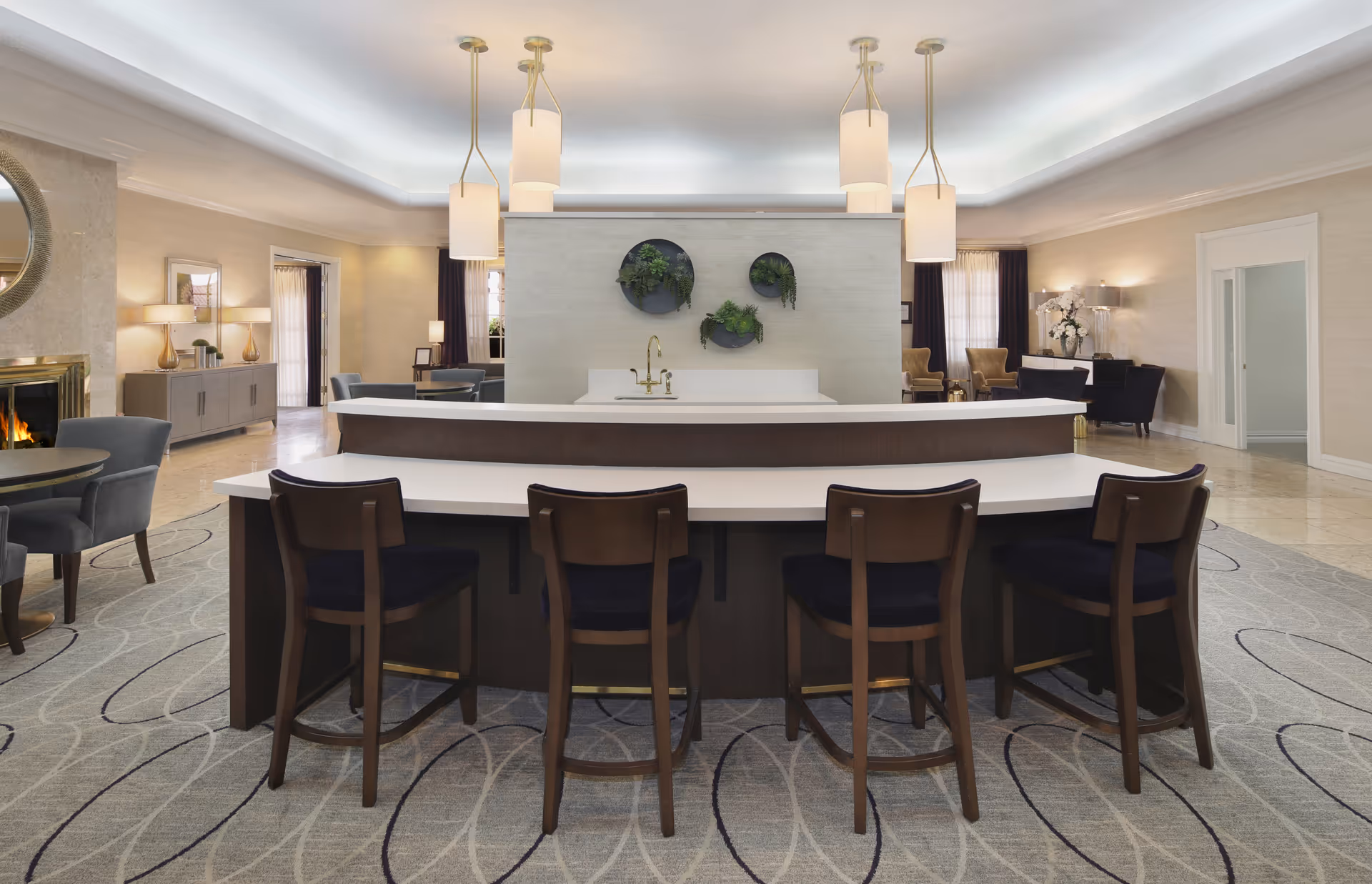 Modern senior living lobby with a curved reception desk, seating areas, and ambient lighting.