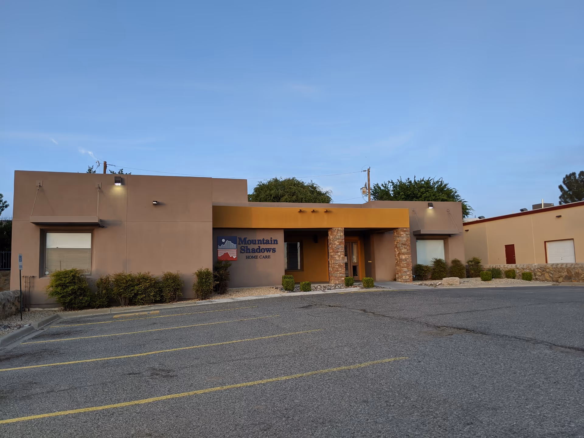 Exterior view of Mountain Shadows Home Care building with parking lot and entrance.