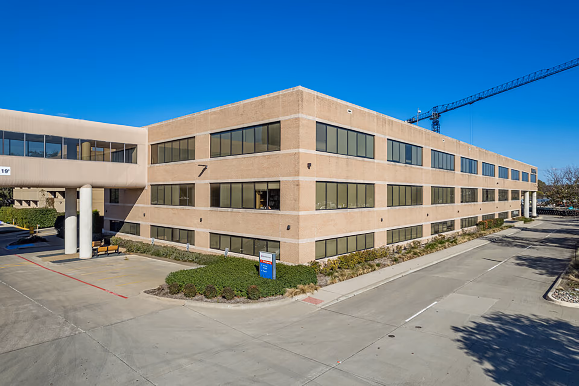 Exterior view of a brick clinic building with many windows under a blue sky.
