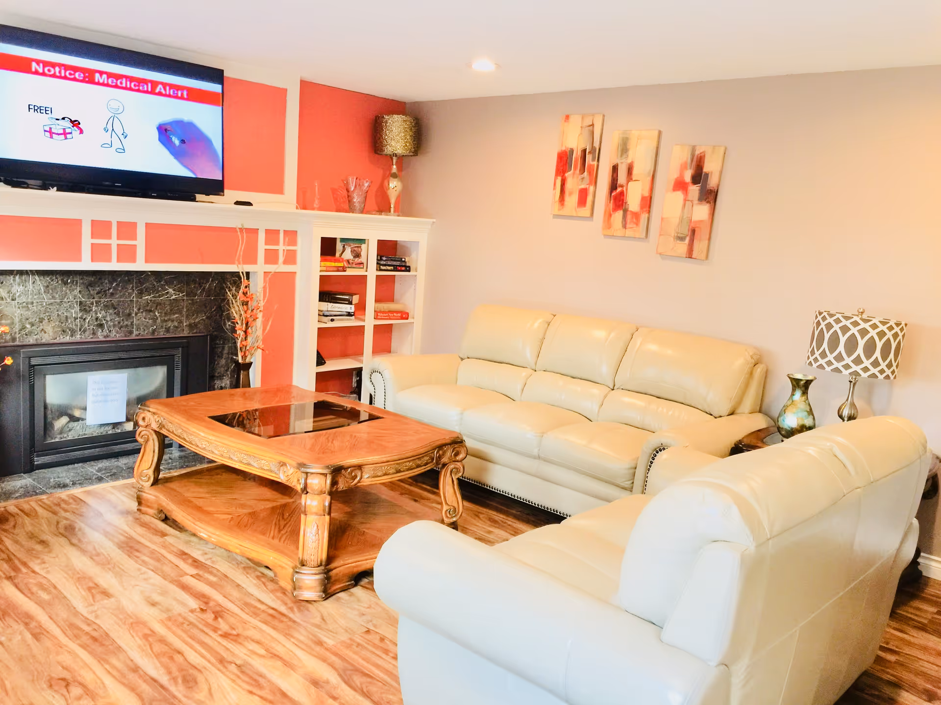 Cozy living room with cream leather sofas, a wooden coffee table, fireplace, and TV.