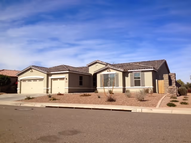 Single-story senior living facility with beige exterior and three-car garage.