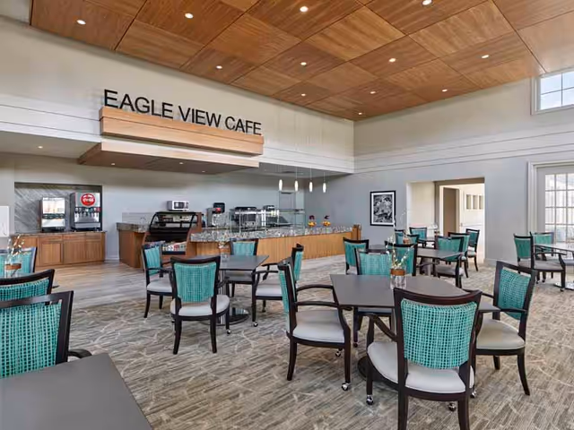 Spacious cafe area with turquoise chairs, dark tables, and a service counter labeled Eagle View Cafe.