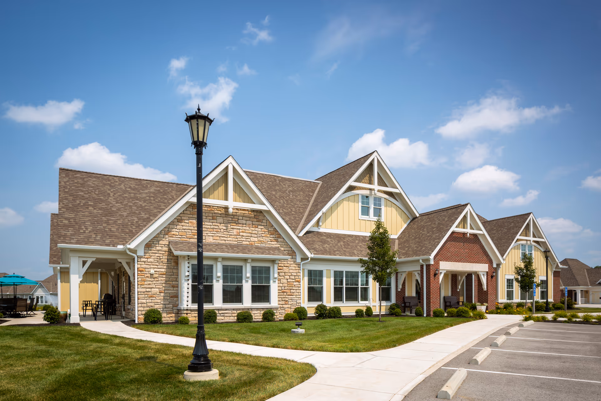 Front exterior view of Otterbein Sunset Village SeniorLife Community with stone facade and gabled roofs.