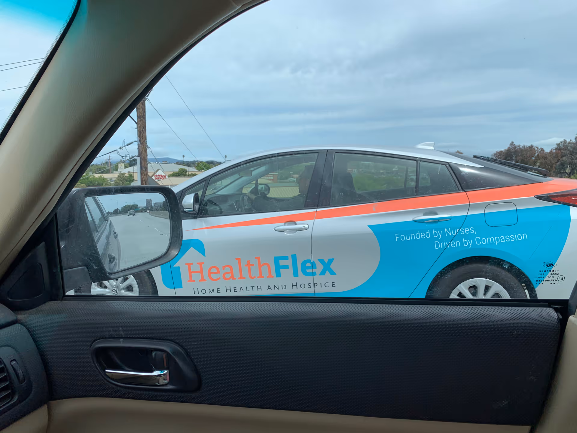 Branding on a HealthFlex van seen through a car window.