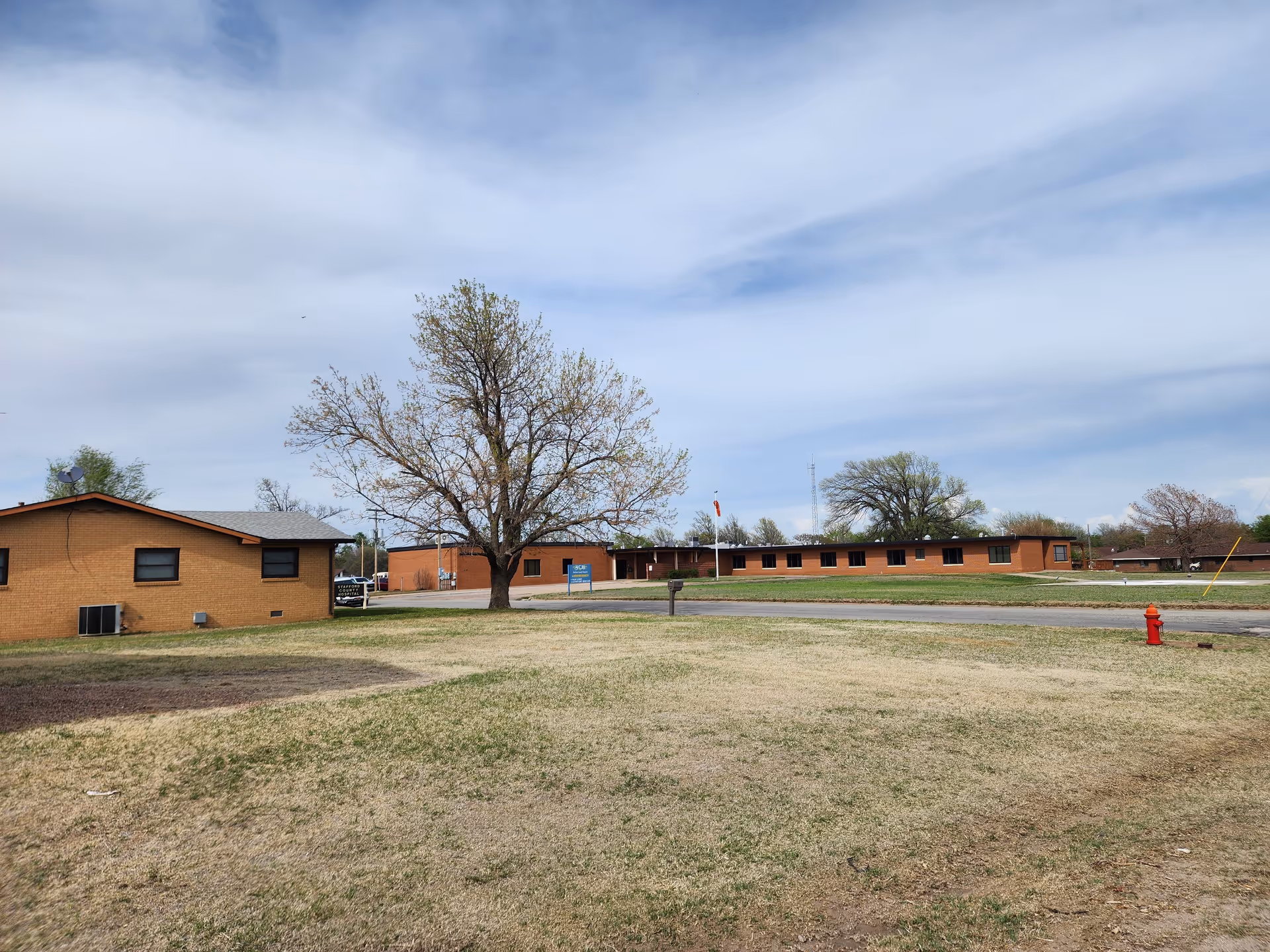 Exterior view of Stafford County Hospital Home Health building with a tree and parking area.