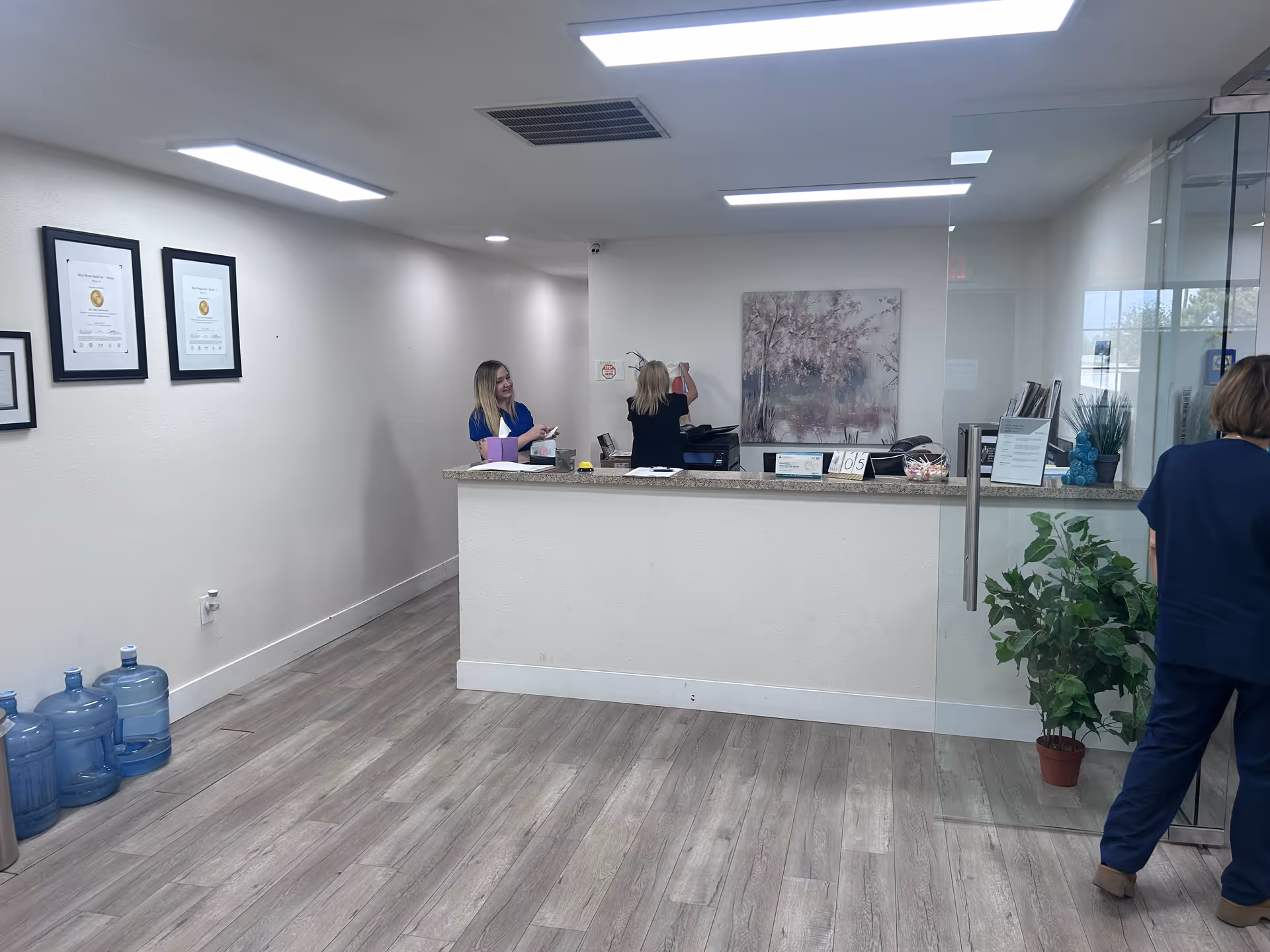 Reception desk in a bright facility with staff at the counter.