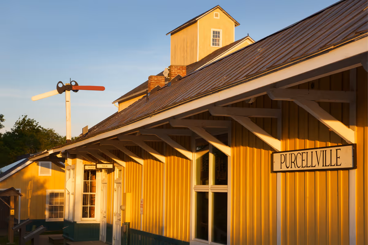 Yellow wooden building with white trim and Purcellville sign under a blue sky.