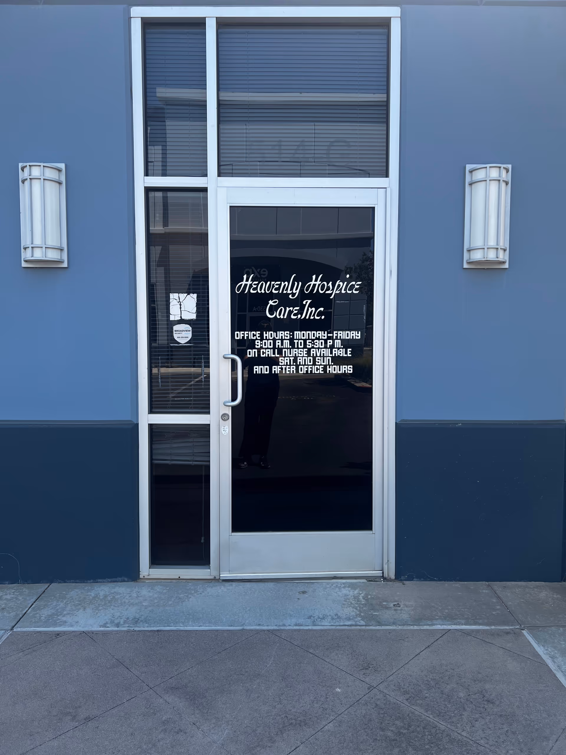 Glass door entrance displays Heavenly Hospice Care, Inc. signage on a blue building exterior.