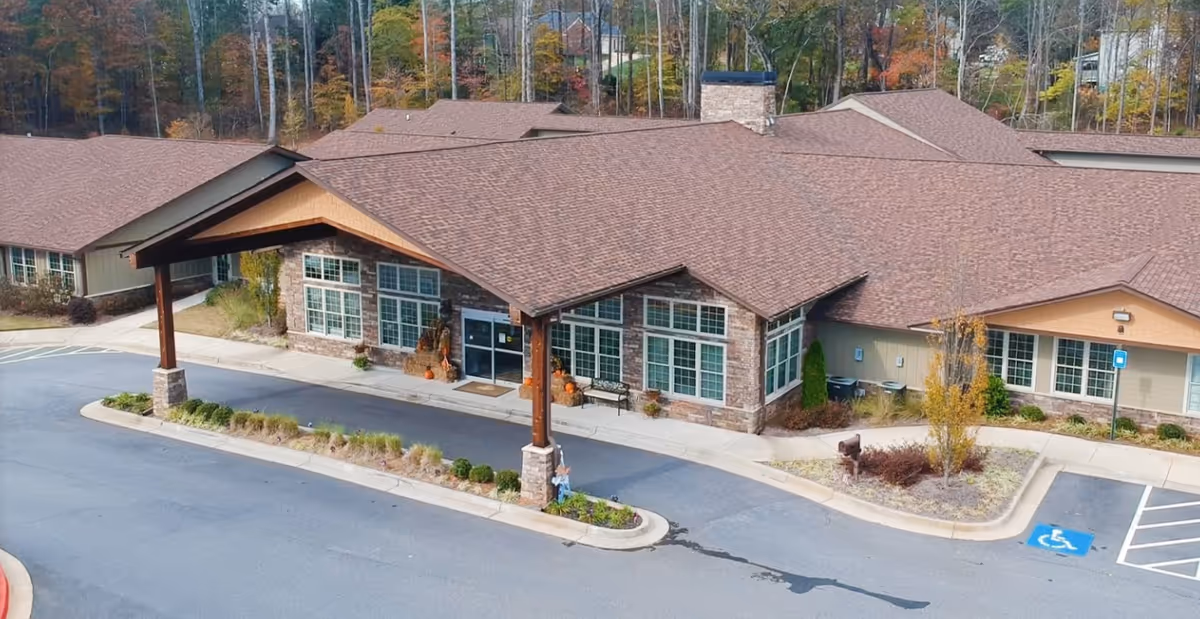 A single-story senior living facility with brown roof, front entrance, and parking lot.