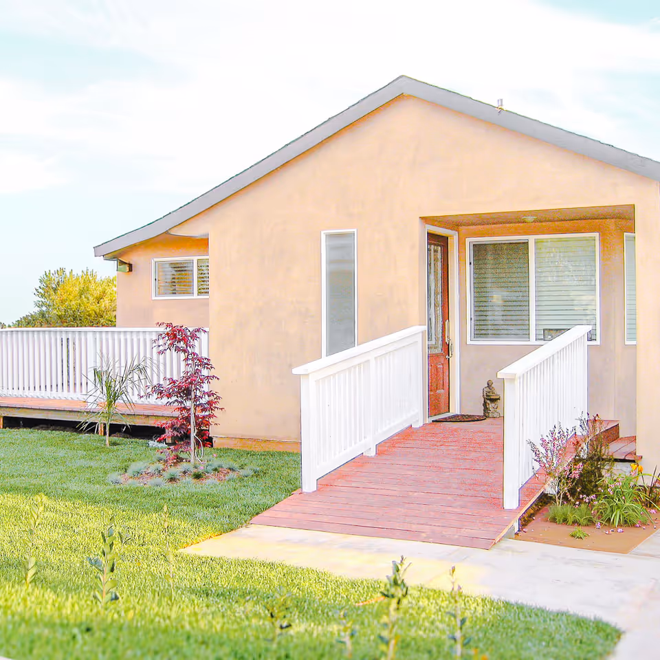 Peach-colored single-story building with a ramp leading to a front door.
