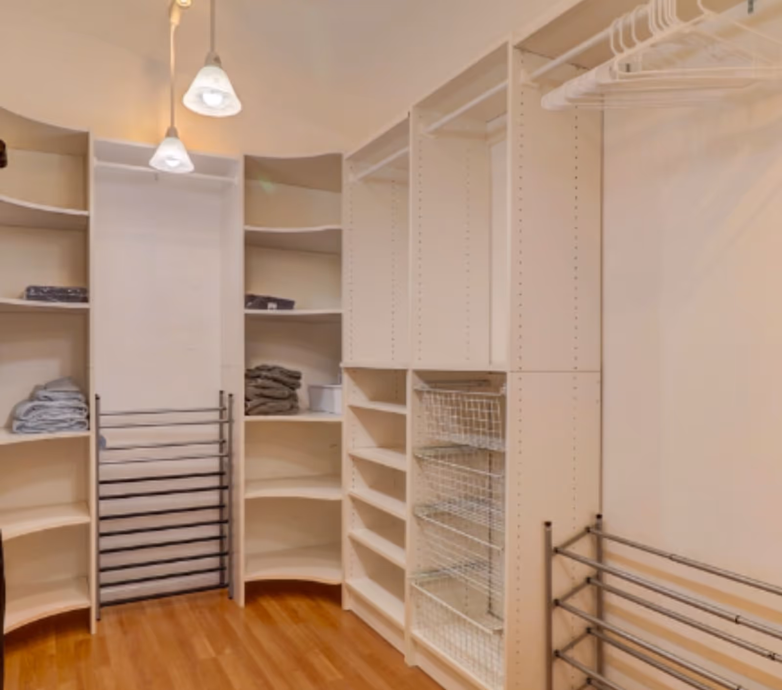 Clean, organized walk-in closet with shelves, hanging rods, and storage bins.