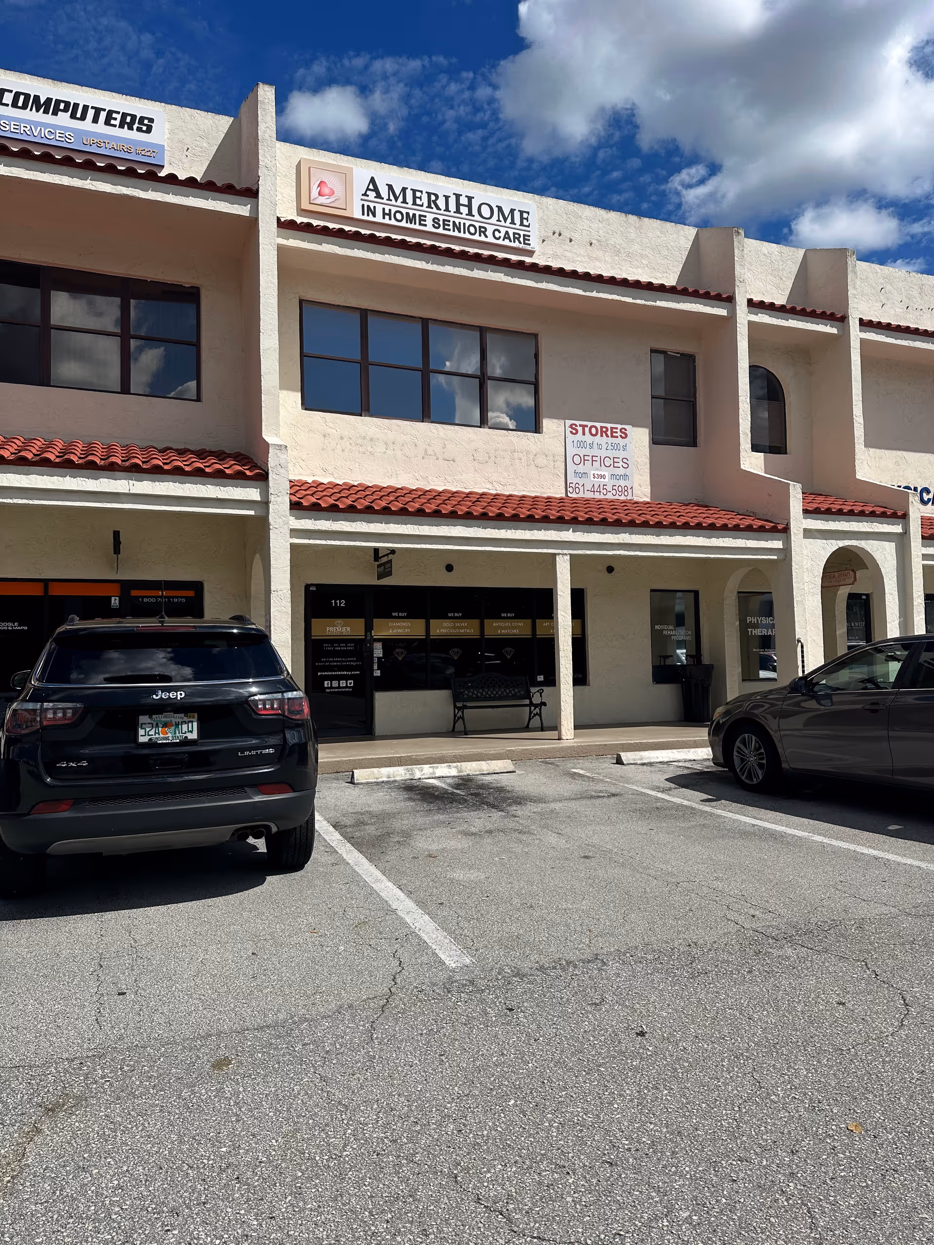 Exterior storefront with AmeriHome Senior Care sign and parked cars.