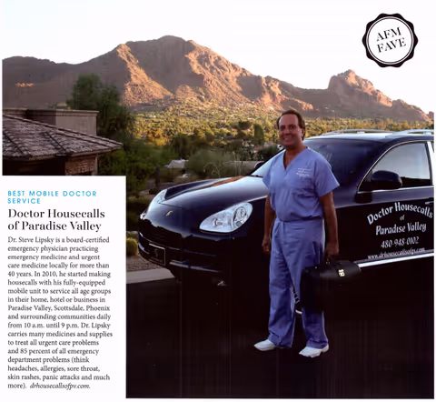 A doctor in scrubs stands beside a van with a medical service brochure, mountains in background