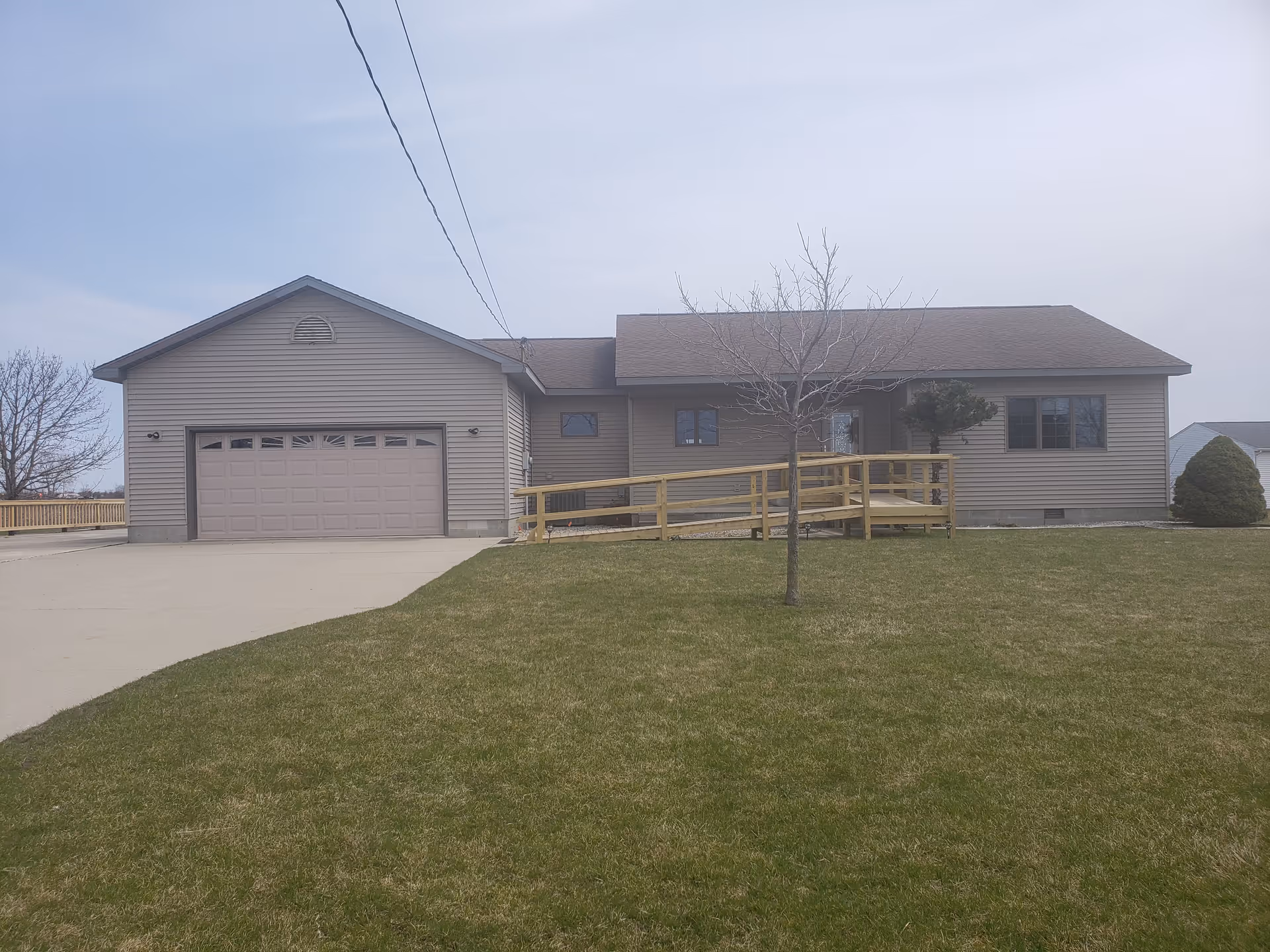 Exterior of a single-story senior living facility with a ramp and garage.