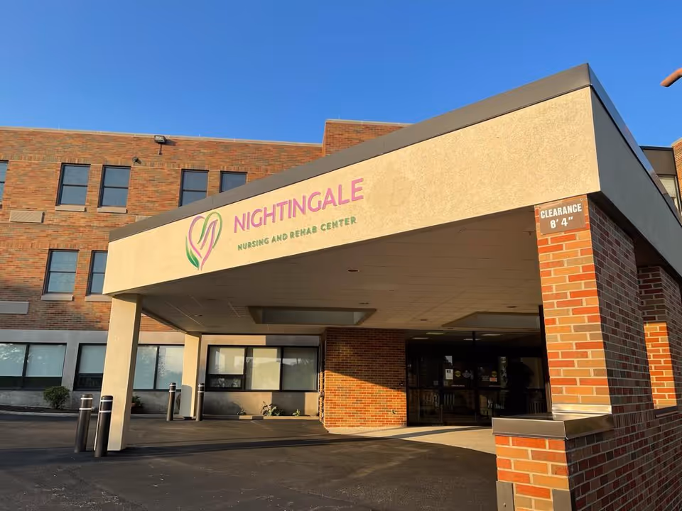 Exterior view of Nightingale Nursing and Rehab Center entrance against a clear blue sky.