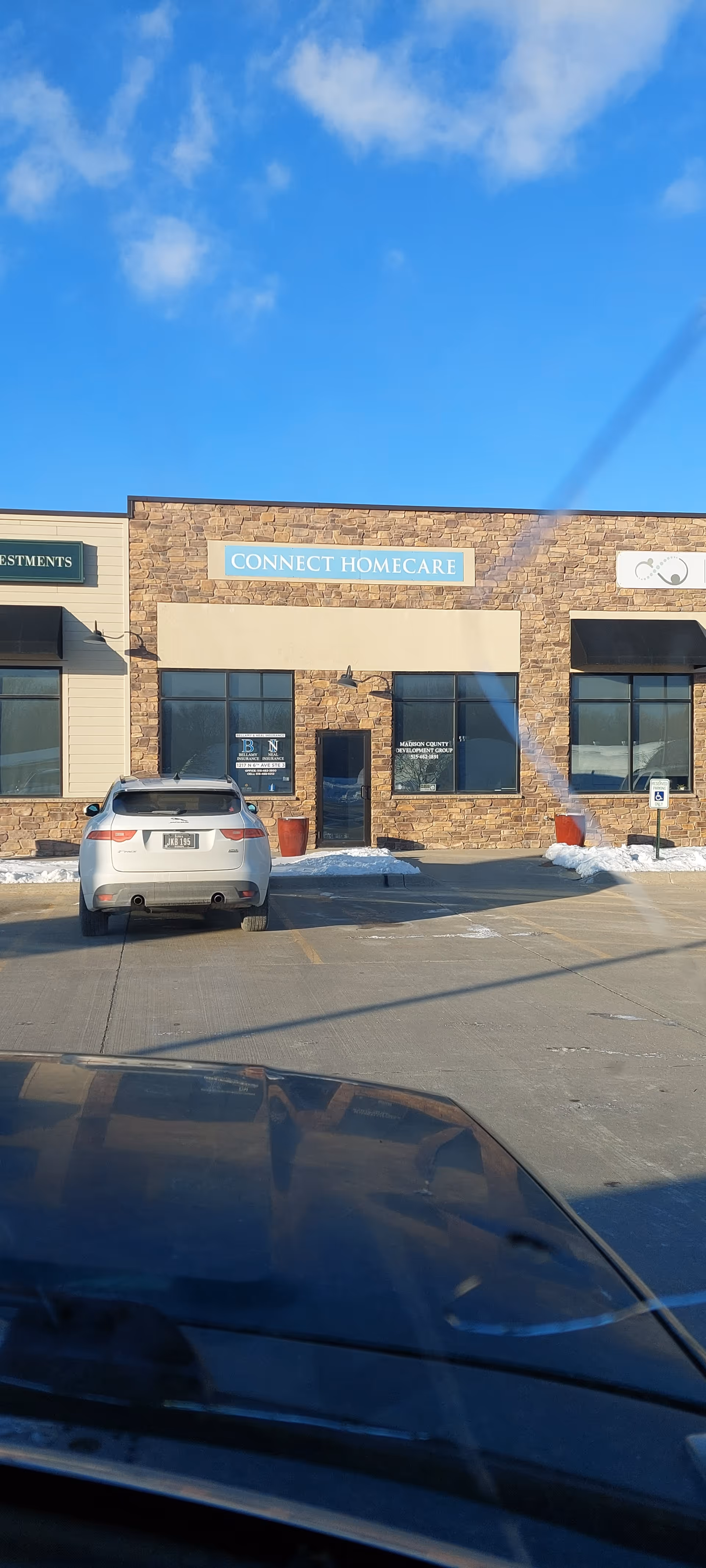 Exterior view of Connect Homecare building with brick facade and parked cars.