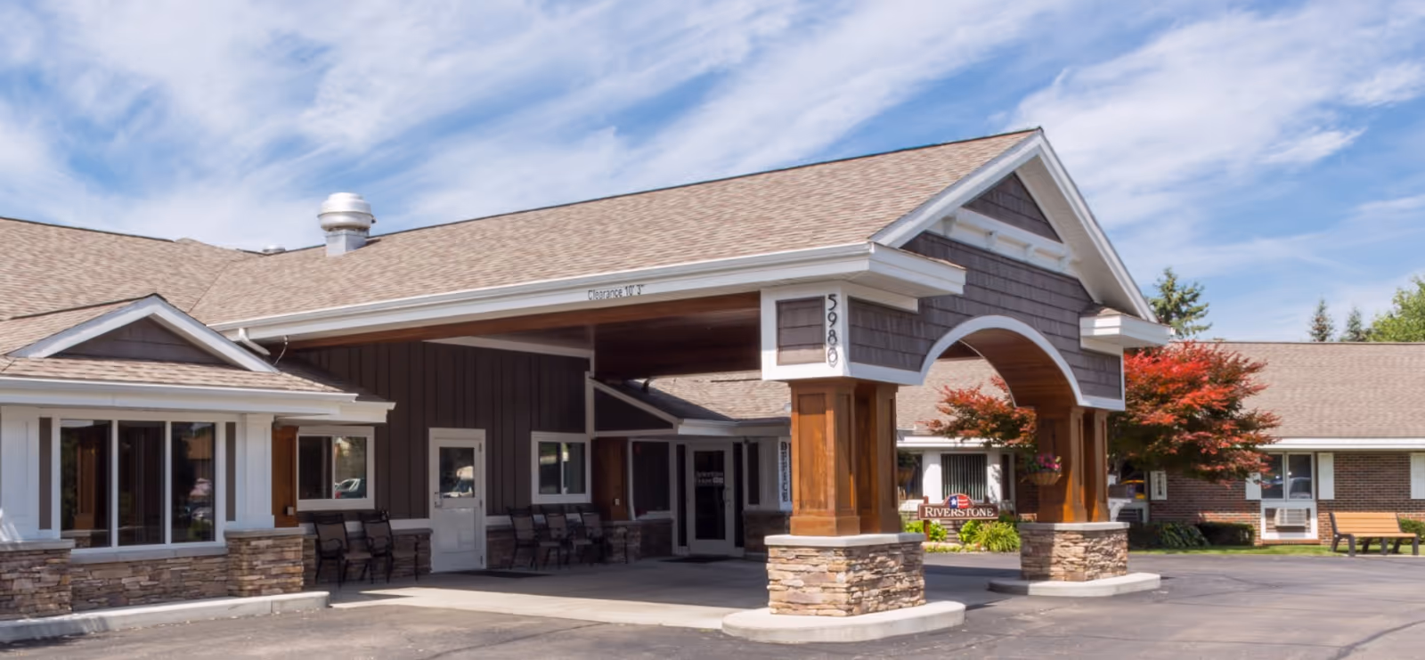 Exterior view of Liberty senior living facility entrance with archway and stone columns.