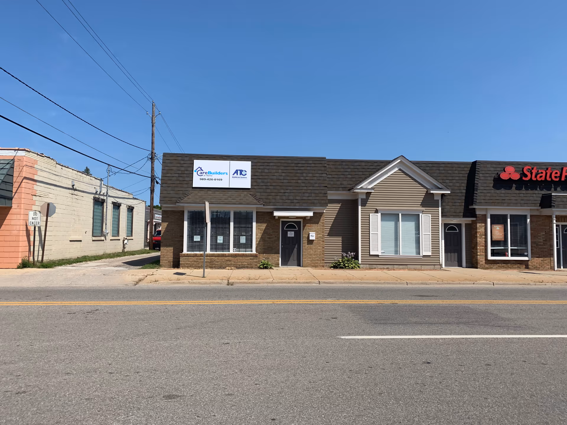 Front view of a row of storefronts on a street, featuring CareBuilders At Home.