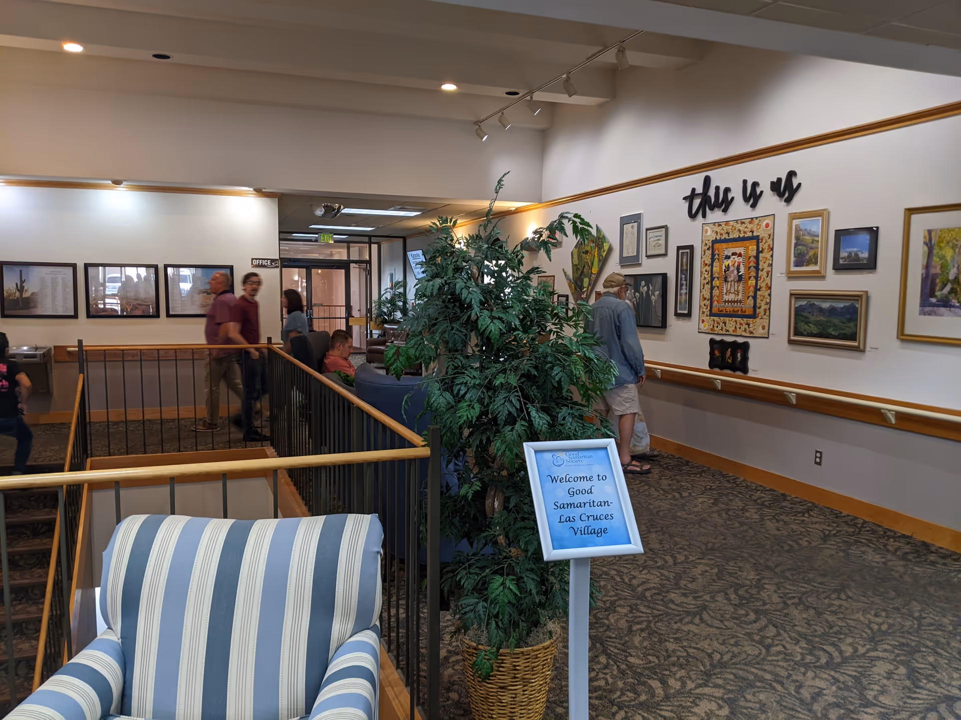 Lobby interior of a senior living facility with seating, plants, and wall art.