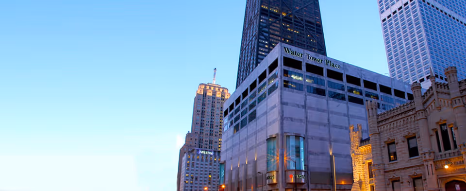 City skyline with tall buildings and a clear blue sky, Water Tower Place signage visible.