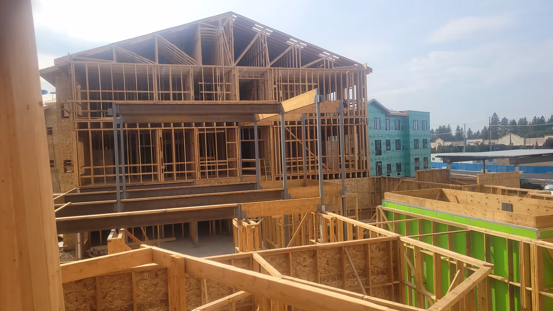 A wooden-framed building under construction with exposed beams and scaffolding.