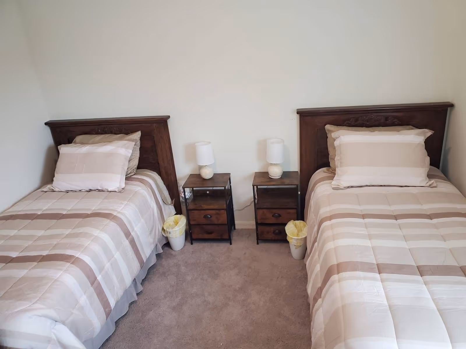 Two single beds with matching bedding and nightstands in a shared bedroom.