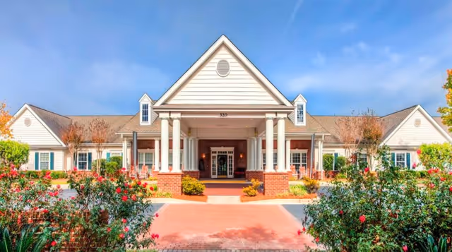 Front view of Oaks at Daniel Island with columns, brick base, and welcoming entrance.